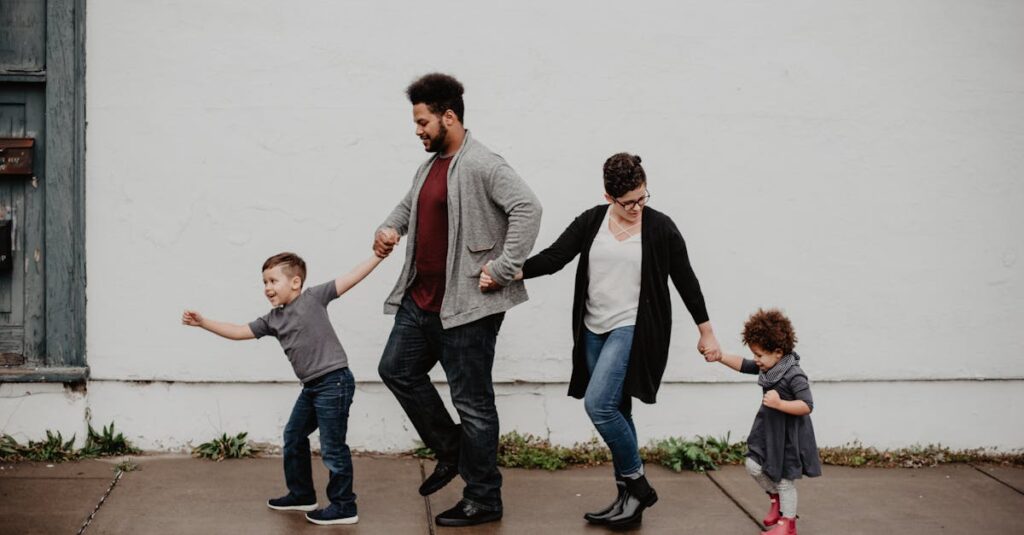 A joyful family walking together outdoors, holding hands in a playful and happy moment.